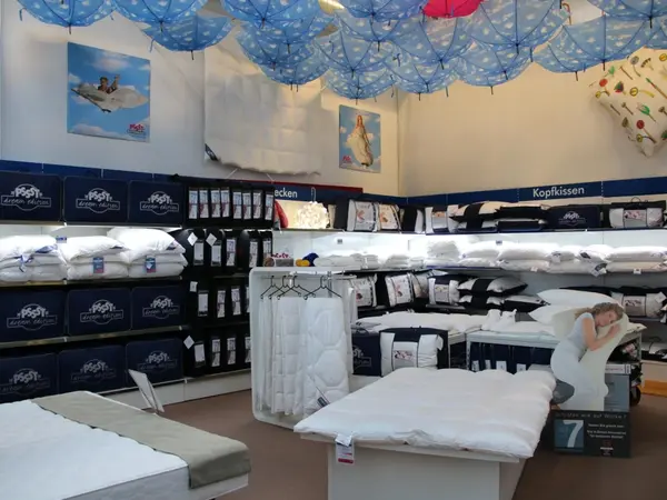 Bettwaren-Geschäft mit Kissen, Decken und Bettdecken-Ausstellung im Laden