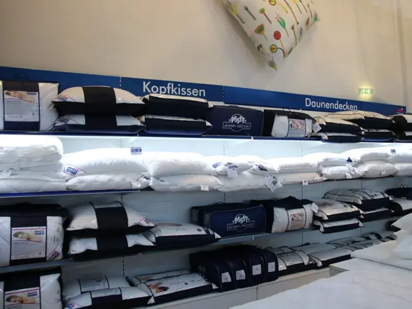 Regal im Bettenfachgeschäft mit Kopfkissen und Daunendecken in Auswahl