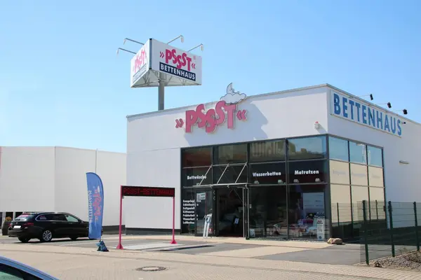 Das Bild zeigt das Bettenhaus Pssst mit moderner Glasfassade und großem Firmenschild.