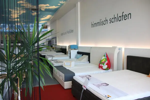 Moderne Bettenausstellung mit gemütlichen Matratzen und stilvoller, heller Raumgestaltung.